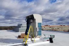 Technician finalizing the installation of a Mitsubishi Ductless Heat Pump in Waltham, MA.