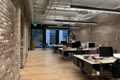 Exposed VRF System including  ERV/fresh air ductwork and ceiling-mounted casettes installed for an open office space.