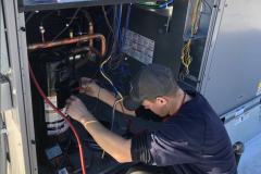 Technician testing a compressor on a 15-ton Packaged Rooftop Unit in Malden, MA.