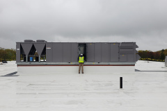 Technician finalizing the installation of a Carrier Packaged Rooftop unit prior to final startup.