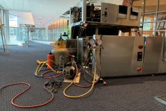 Technicians prepare a  water source heat pump unit for installation. System was disassembled prior to installation to allow for the equipment to be brought into the building piece-by-piece.