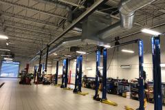Exposed spiral ductwork for a 20-ton rooftop unit serving an automotive service bay in Braintree, MA.